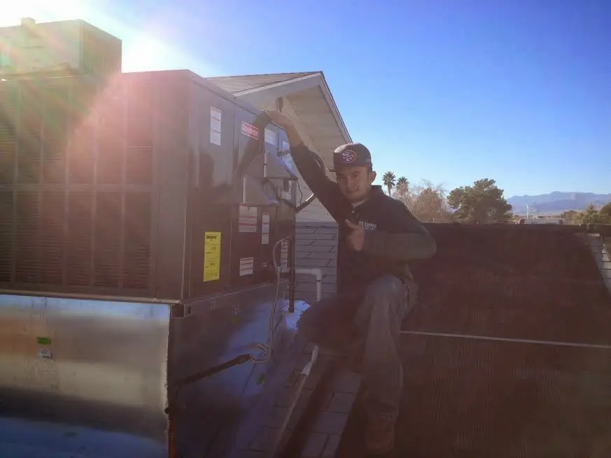 HVAC technician performing Heat Pump Repair on a rooftop unit in Hamtramck